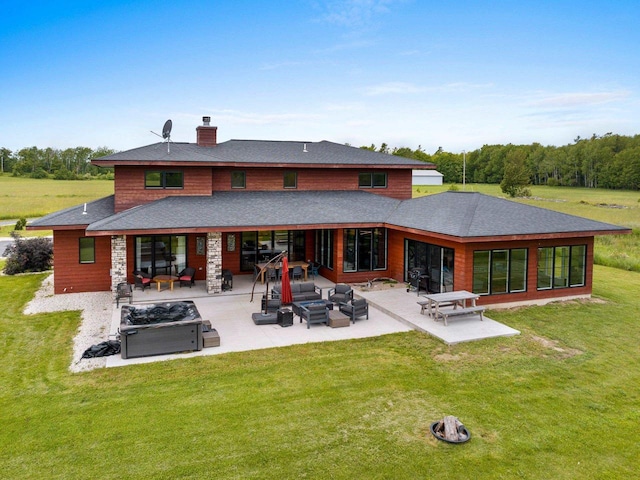 rear view of house with a yard, an outdoor living space, a patio, and a hot tub