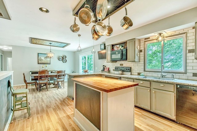 kitchen featuring sink, pendant lighting, a kitchen island, black appliances, and light wood-type flooring