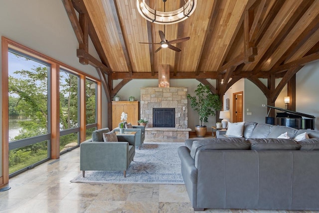 living room with a stone fireplace, ceiling fan, beamed ceiling, and high vaulted ceiling