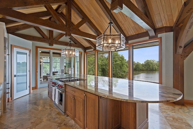 kitchen with designer range, a large island with sink, decorative light fixtures, and a notable chandelier