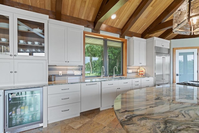 kitchen featuring appliances with stainless steel finishes, light stone countertops, white cabinetry, and wine cooler