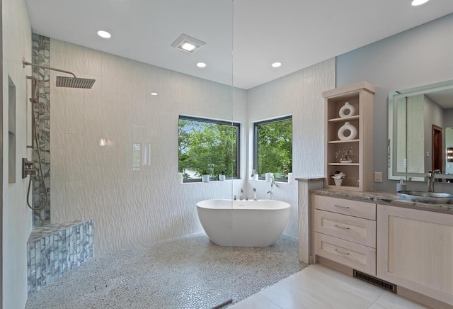 bathroom featuring tile patterned floors, vanity, separate shower and tub, and tile walls