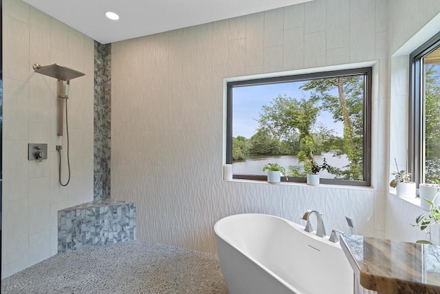 bathroom featuring tile walls and shower with separate bathtub