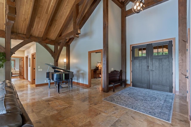 foyer entrance with beamed ceiling, high vaulted ceiling, wood ceiling, and an inviting chandelier