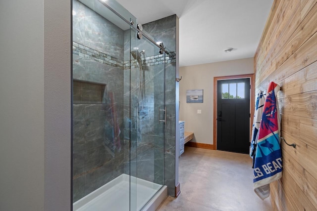 bathroom featuring wooden walls and a shower with door