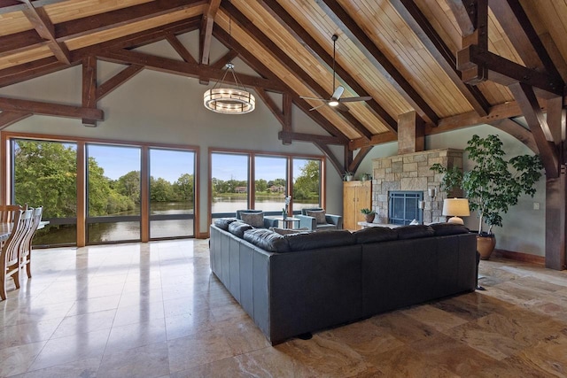 living room featuring a fireplace, ceiling fan with notable chandelier, a water view, high vaulted ceiling, and beamed ceiling