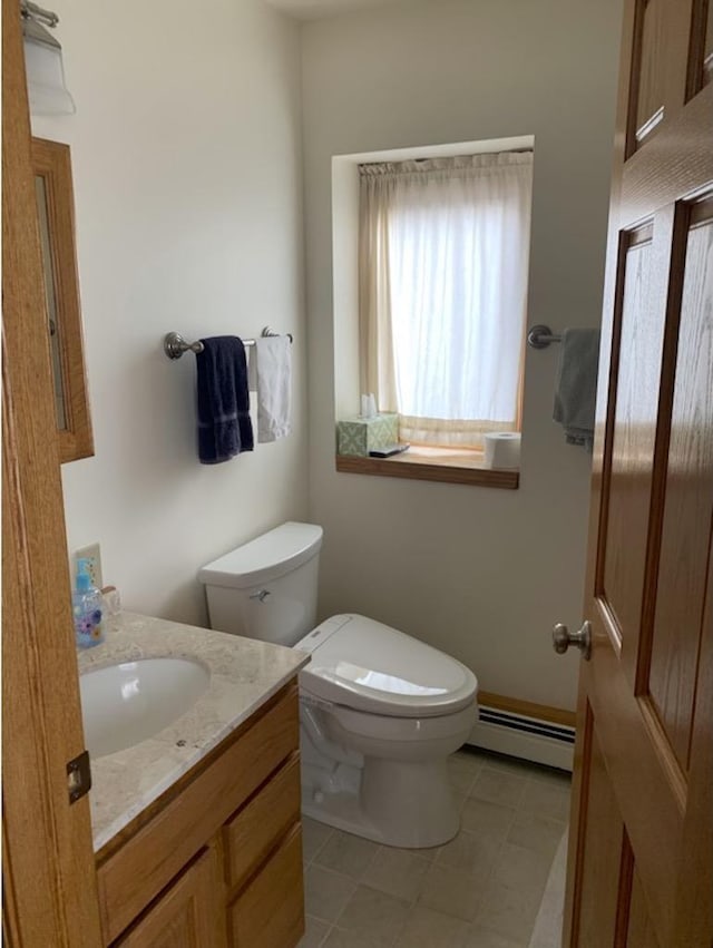 bathroom with vanity, toilet, and a baseboard heating unit