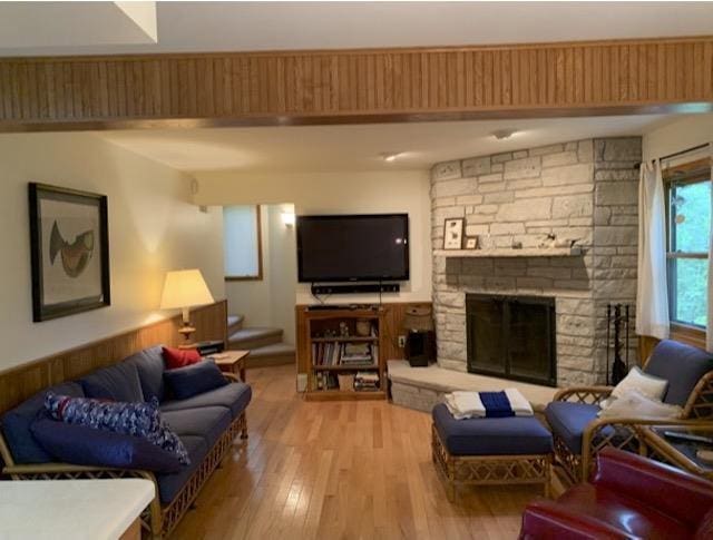 living room featuring light hardwood / wood-style flooring and a stone fireplace