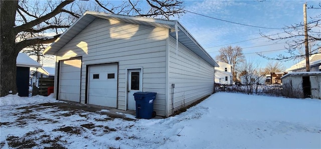 snow covered garage featuring a garage