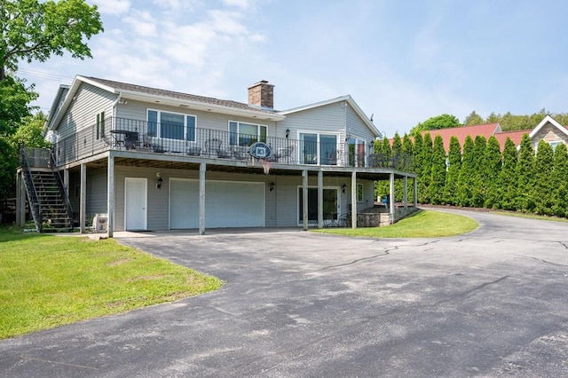 view of front of house featuring a front lawn, a deck, and a garage