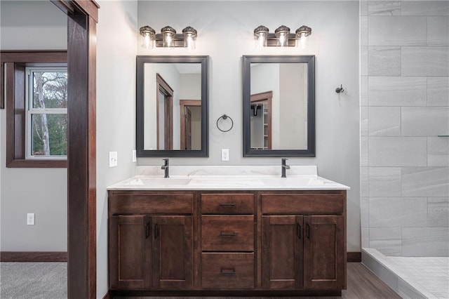 bathroom featuring a tile shower, vanity, and hardwood / wood-style flooring