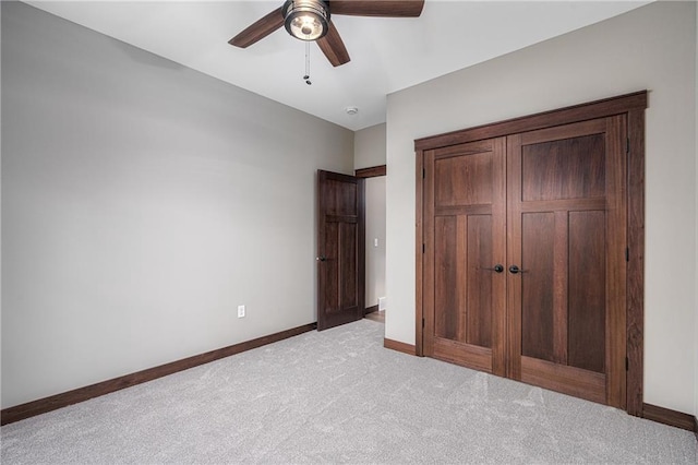 unfurnished bedroom with light carpet, a closet, and ceiling fan