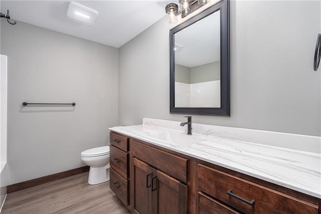 bathroom featuring vanity, toilet, wood-type flooring, and walk in shower