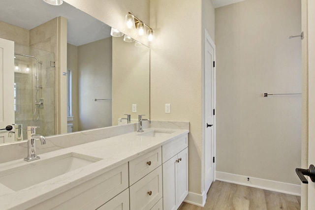 bathroom with hardwood / wood-style floors, vanity, and walk in shower