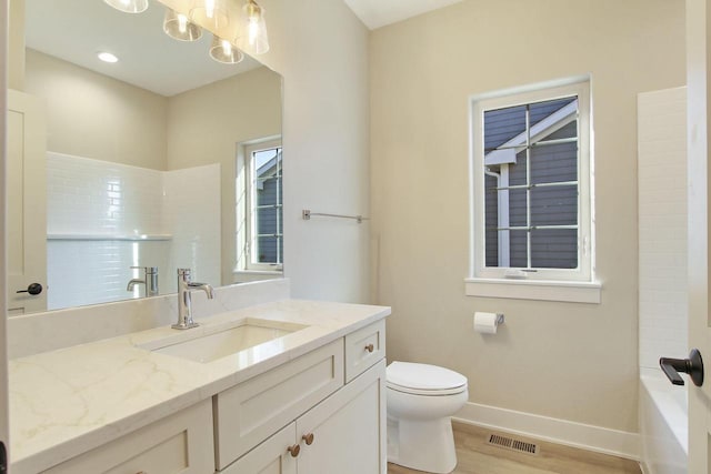 4703 98th St, Pleasant Prairie, WI 53158 - full bathroom with wood finished floors, toilet, vanity, baseboards, and visible vents