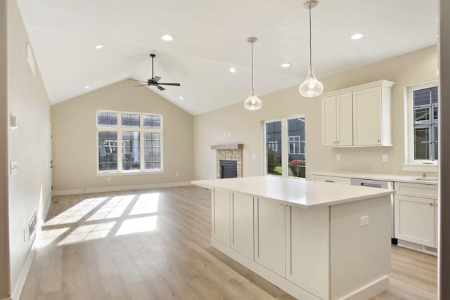 kitchen with ceiling fan, a center island, white cabinetry, and light hardwood / wood-style flooring