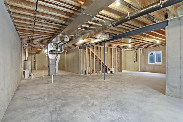 basement featuring electric panel, gas water heater, and heating unit