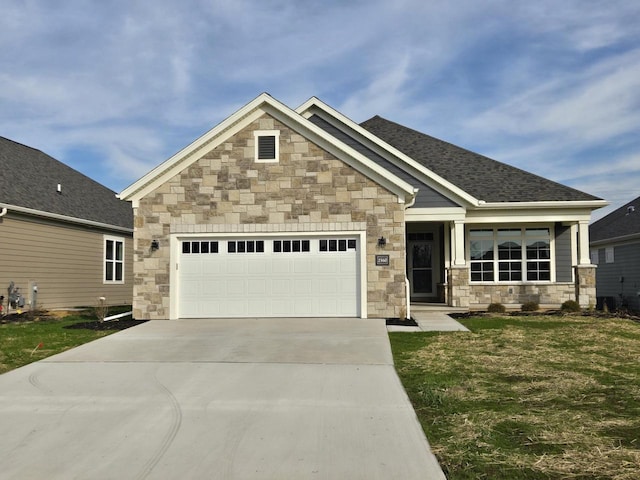 craftsman house featuring a front yard and a garage