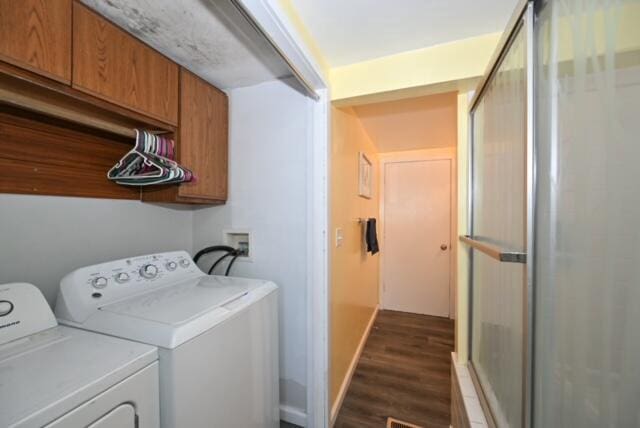 laundry room featuring washer and dryer, dark hardwood / wood-style floors, and cabinets