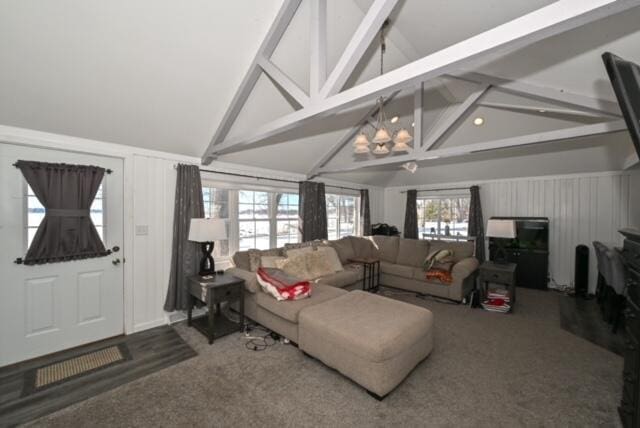 living room with carpet, lofted ceiling with beams, and an inviting chandelier