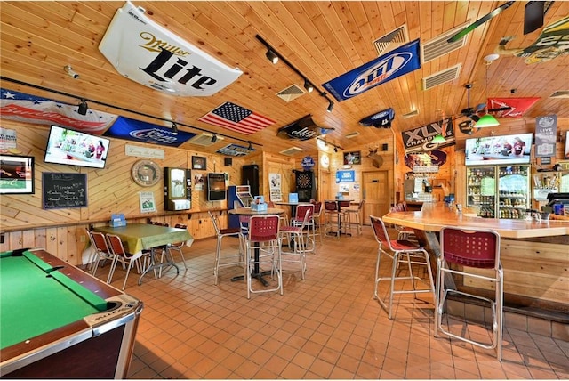 rec room with wood walls, light tile patterned flooring, rail lighting, and pool table