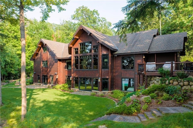 back of house with a wooden deck and a lawn