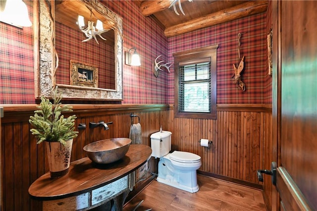 bathroom with wood ceiling, sink, beamed ceiling, hardwood / wood-style floors, and toilet