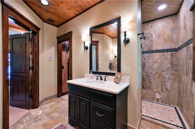 bathroom featuring a tile shower, vanity, and wooden ceiling