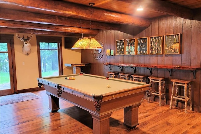 rec room featuring beamed ceiling, indoor bar, wooden walls, and wood ceiling