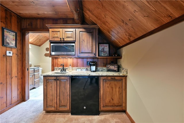 bar featuring sink, stainless steel microwave, black dishwasher, light stone counters, and wood walls