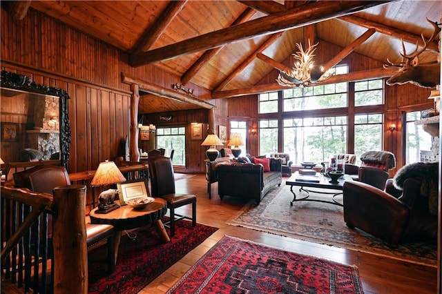 living room with an inviting chandelier, beamed ceiling, high vaulted ceiling, wooden walls, and wood ceiling