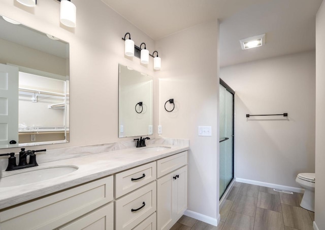 bathroom featuring toilet, vanity, and walk in shower