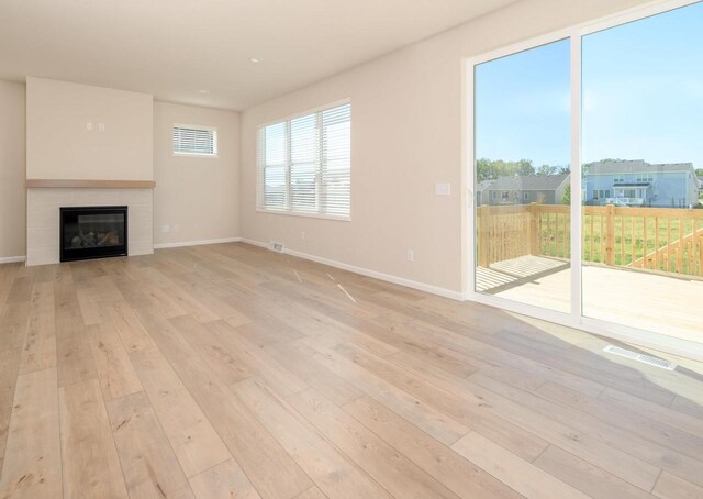 unfurnished living room featuring a fireplace and light hardwood / wood-style flooring