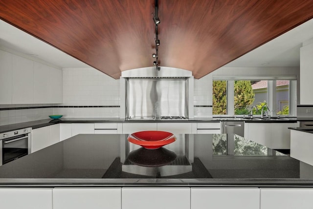 kitchen featuring white cabinets, rail lighting, and stainless steel appliances