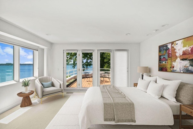 bedroom featuring carpet, access to outside, and a water view