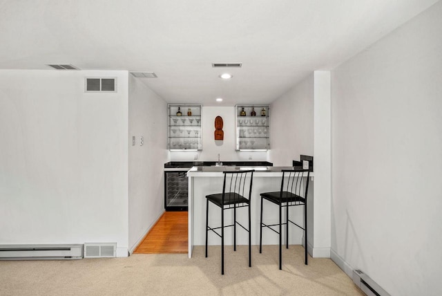 bar with a baseboard radiator, beverage cooler, and light colored carpet