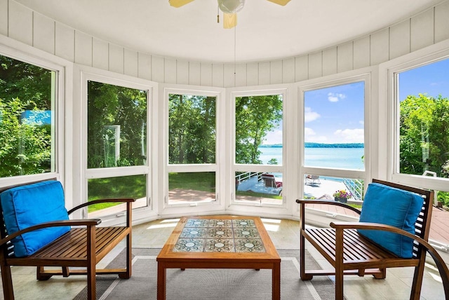 sunroom / solarium featuring ceiling fan and a water view