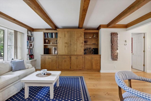 living room with beam ceiling, light wood-type flooring, and built in shelves