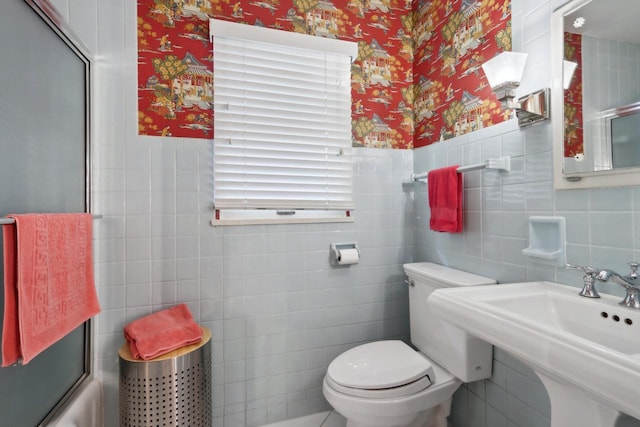 full bathroom with sink, bath / shower combo with glass door, and toilet