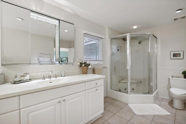 bathroom with tile patterned flooring, vanity, toilet, and an enclosed shower