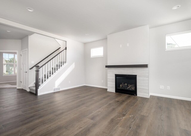 unfurnished living room featuring a fireplace and dark hardwood / wood-style floors