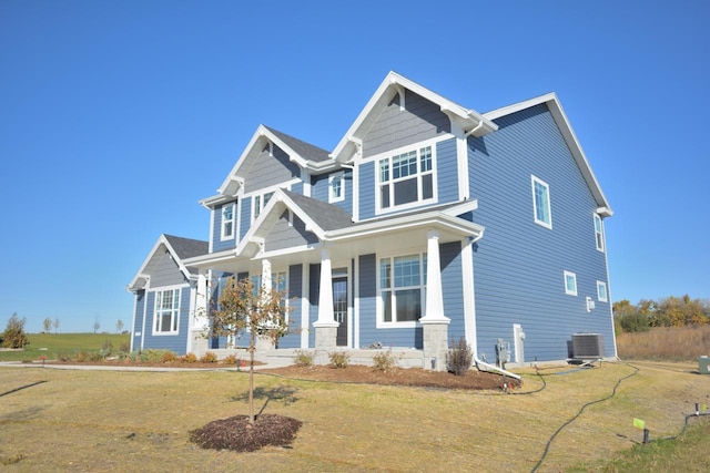 craftsman-style house featuring a porch, central AC unit, and a front lawn