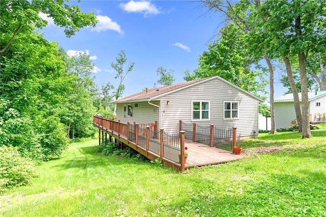 back of property with a lawn and a wooden deck