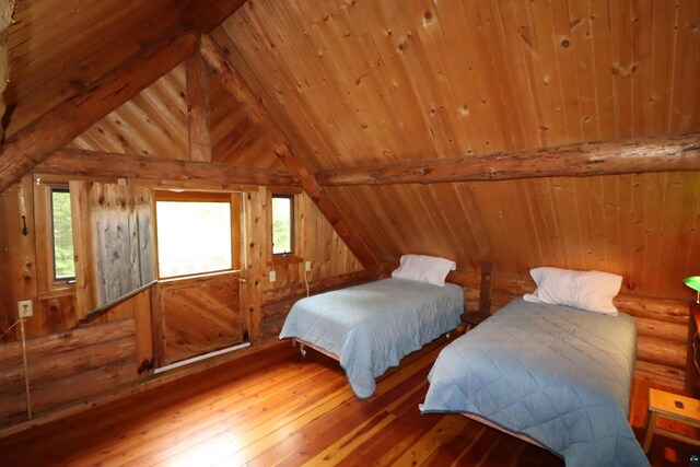 bedroom with hardwood / wood-style floors, lofted ceiling with beams, and wooden ceiling