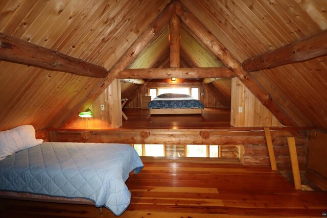 bedroom with vaulted ceiling with beams, hardwood / wood-style flooring, multiple windows, and wood ceiling