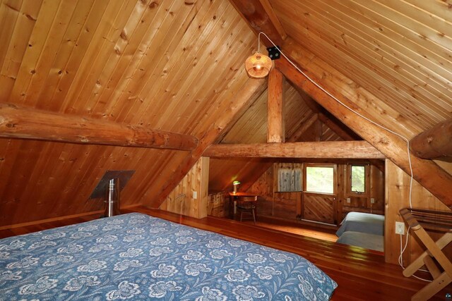 unfurnished bedroom featuring lofted ceiling with beams, wood walls, and wood-type flooring