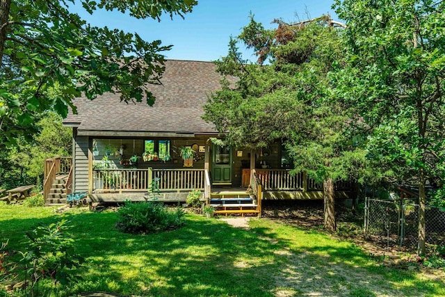 rear view of property featuring a deck and a lawn