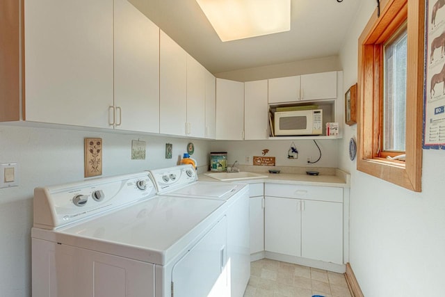 clothes washing area featuring sink, cabinets, and independent washer and dryer