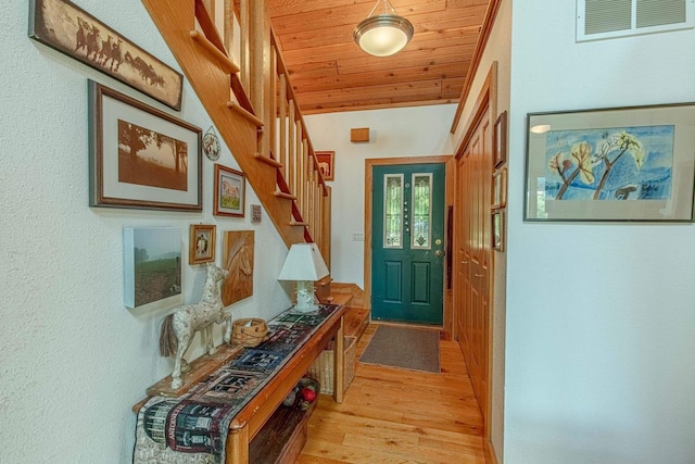 doorway with lofted ceiling, wooden ceiling, and light wood-type flooring