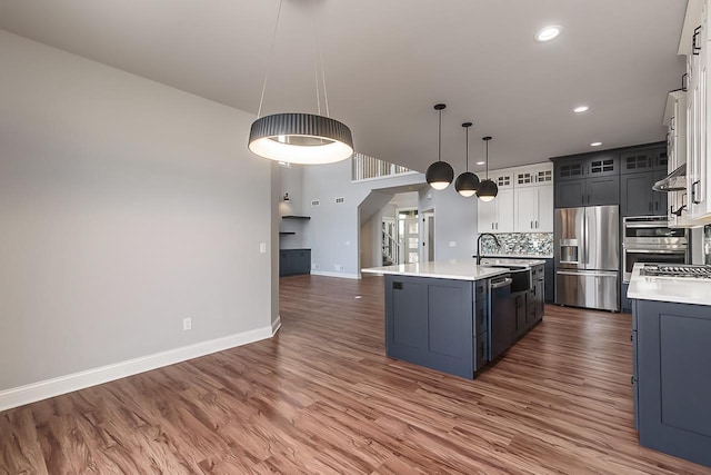 1421 Greenleaf Ct, Sun Prairie, WI 53590 - kitchen featuring appliances with stainless steel finishes, light countertops, baseboards, open floor plan, and wood finished floors